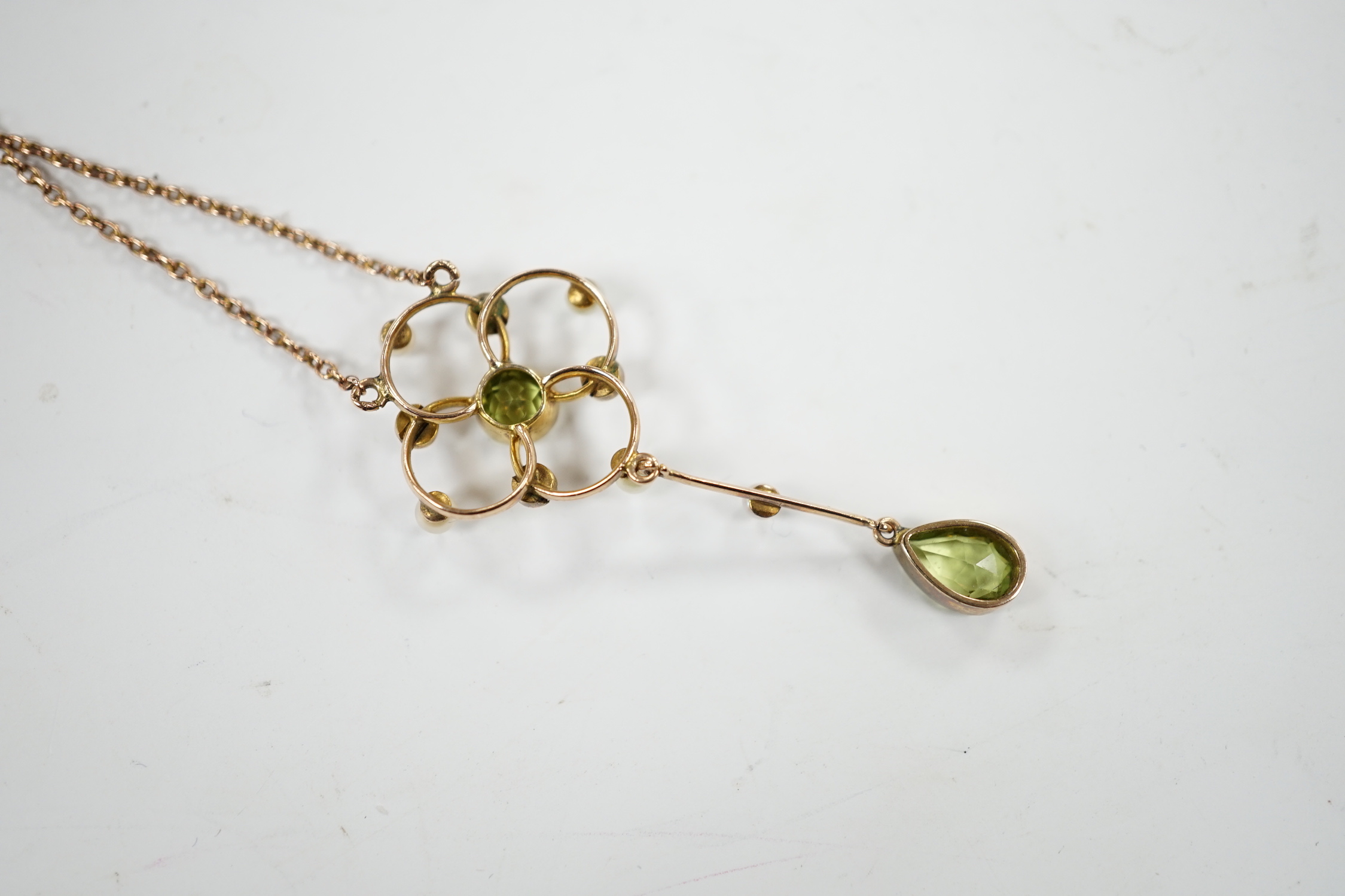An Edwardian 9ct, peridot and seed pearl set drop pendant necklace, 49cm, gross weight 3.5 grams.